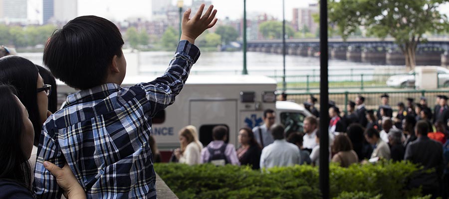 A young Commencement guest waves to the graduates in procession; photo: Dominick Reuter