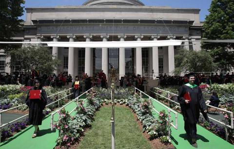 Students exit the Commencement stage with diplomas in hand