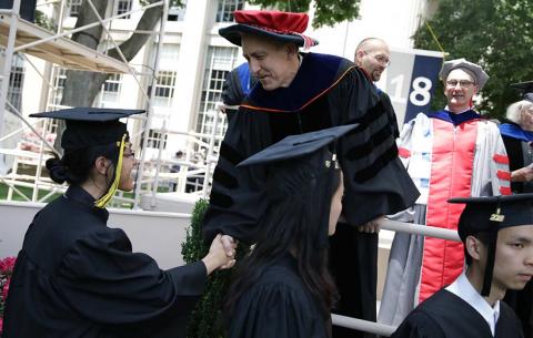 Vice Chancellor Ian Waitz greets graduates from the stage