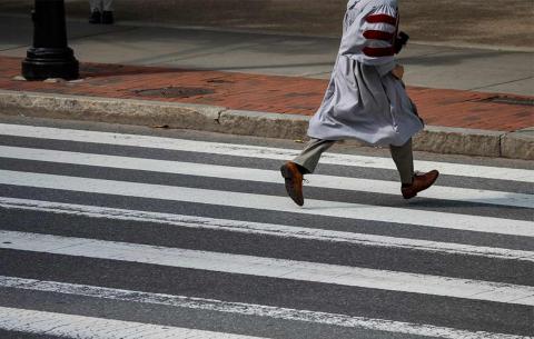 PhD running across crosswalk