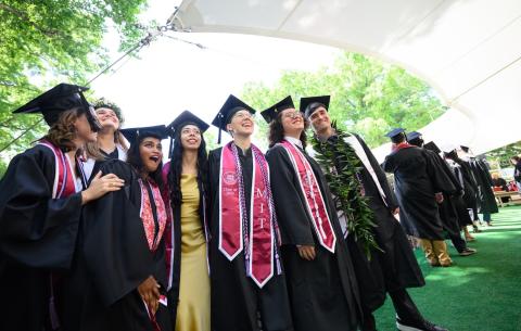 Image of graduates taking a group photo before crossing the stage to receive their diploma