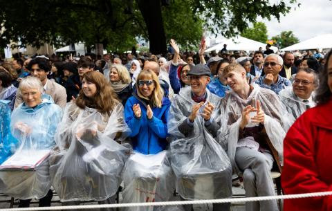 Image of parents in rain ponchos clapping before the OneMIT Commencement Ceremony