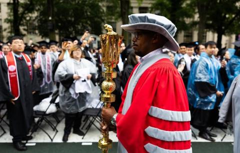 Image of the President of the Alumni Association, R. Robert Wickham holding the ceremonial mace during the procession into Killian Court